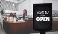 Come in WeÃ¢â¬â¢re OpenÃ¢â¬â¢ on cafe waiter standing in front of coffee shop vintage retro sign Royalty Free Stock Photo